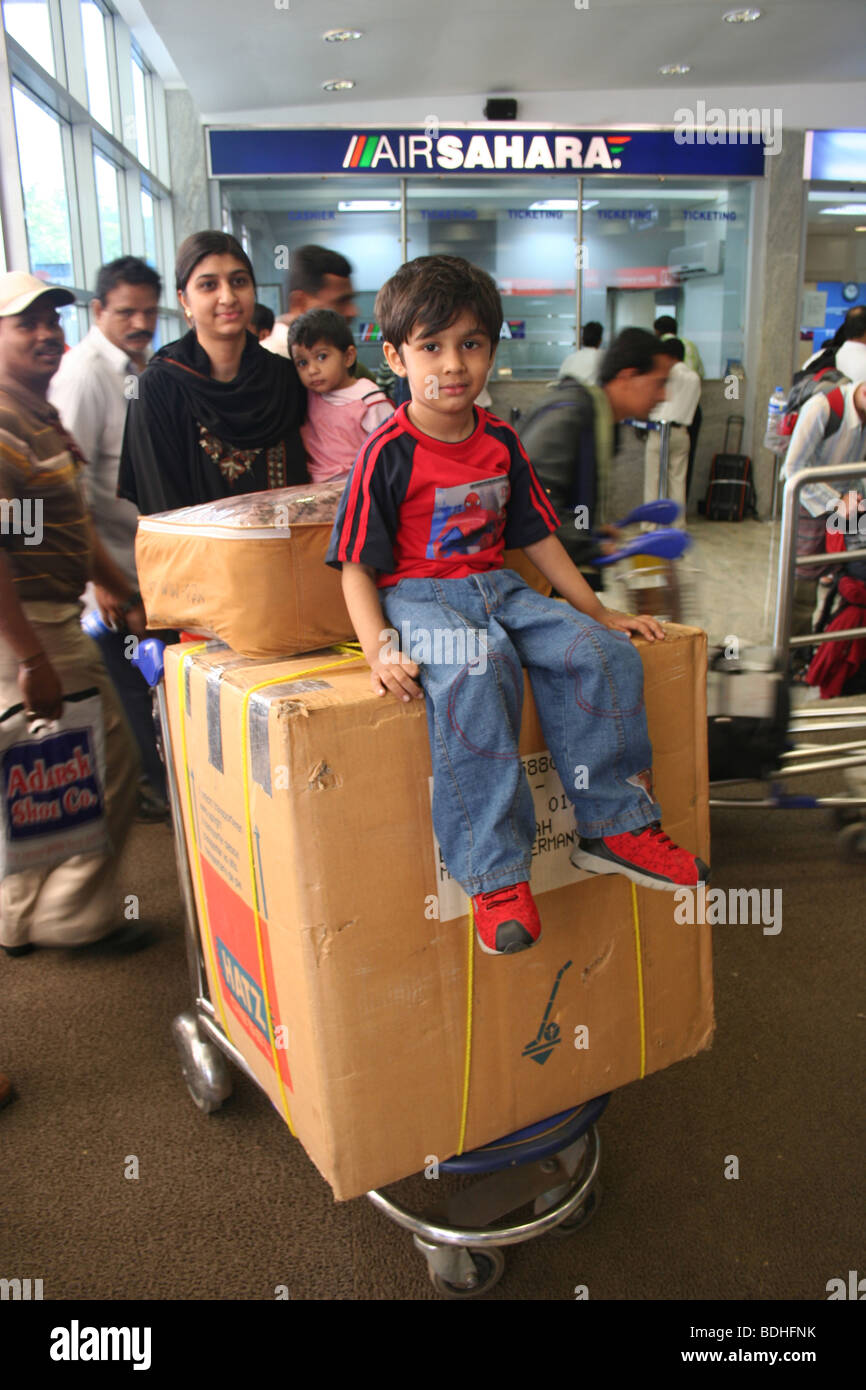Youg boy sitting on baggage trolley mumbai airport Stock Photo - Alamy