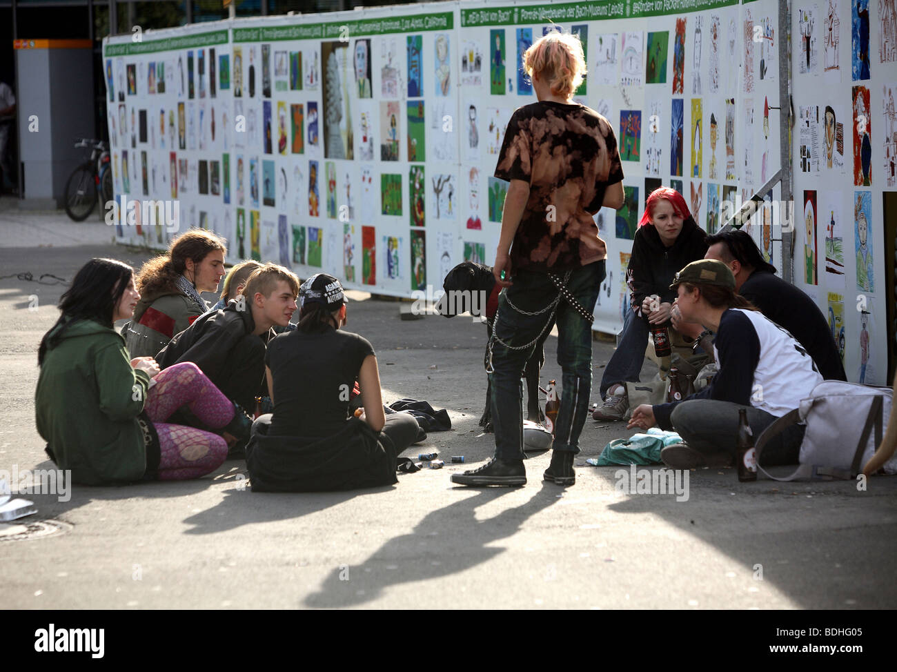 Young people sitting on the street, Leipzig, Germany Stock Photo