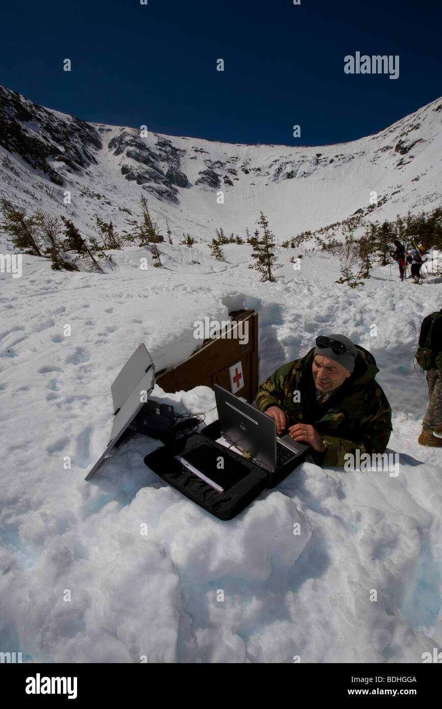 A member of the National Guard sets up a laptop with a satellite dish to transmit Inferno race times to the bottom of the course Stock Photo