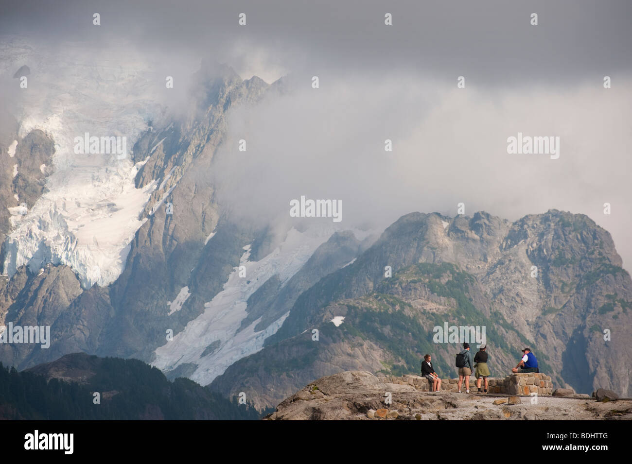 After finishing the Chain Lakes Trail at Mt. Baker, hikers rest at the foot of the glacier on Mt. Shuksan, Washington, USA. Stock Photo