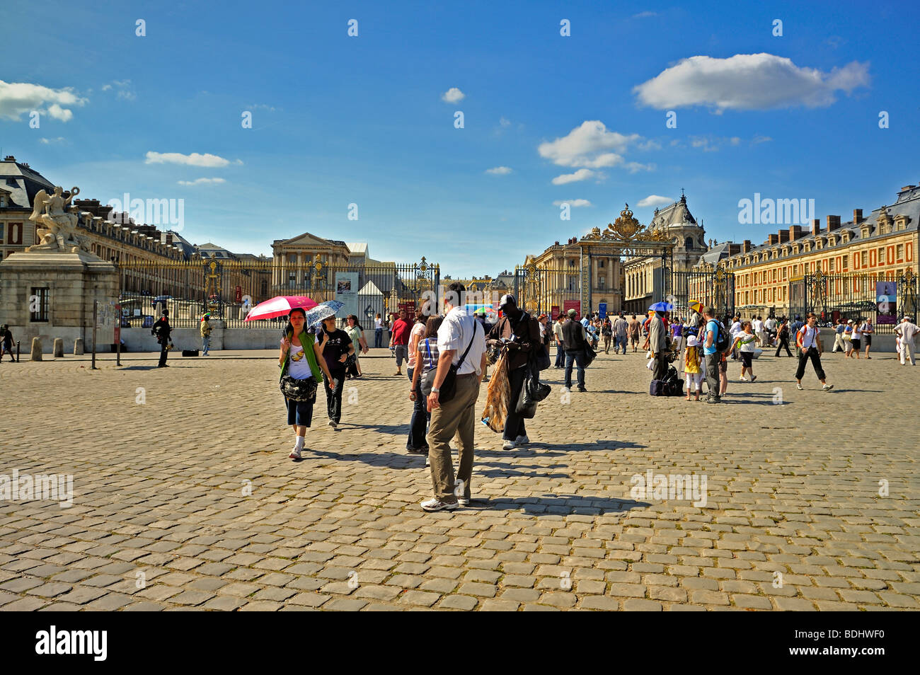 Versailles Palace - Tourists Visiting French Monument, 'Chateau de Versailles', with Immigrant Sidewalk Souvenir Hawker, front of French chateau, Stock Photo