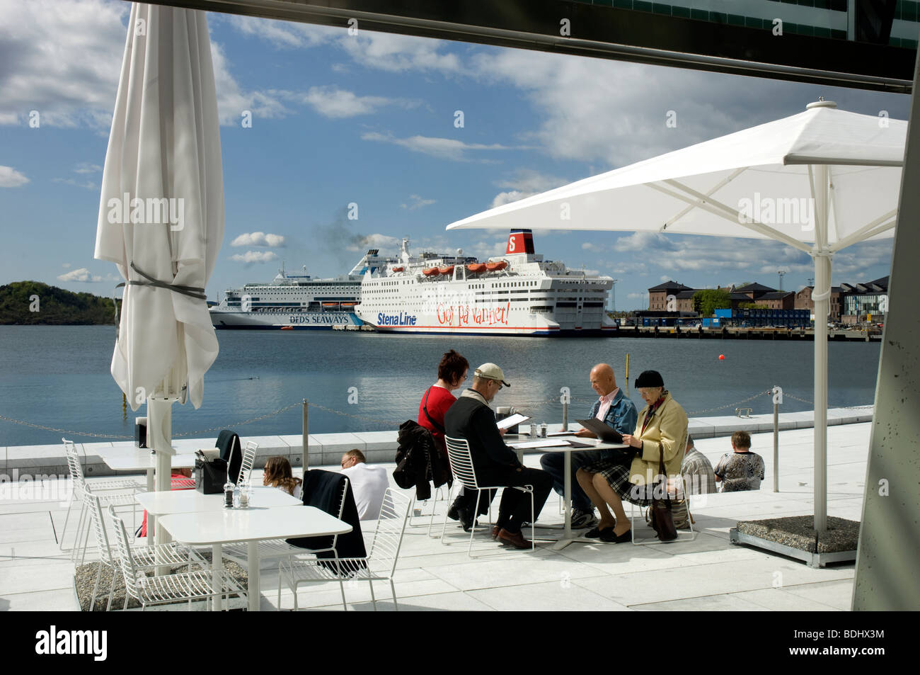 Oslo's new opera house has an attractive cafe and restaurant right on the water's edge. Two huge car ferries in the background. Stock Photo