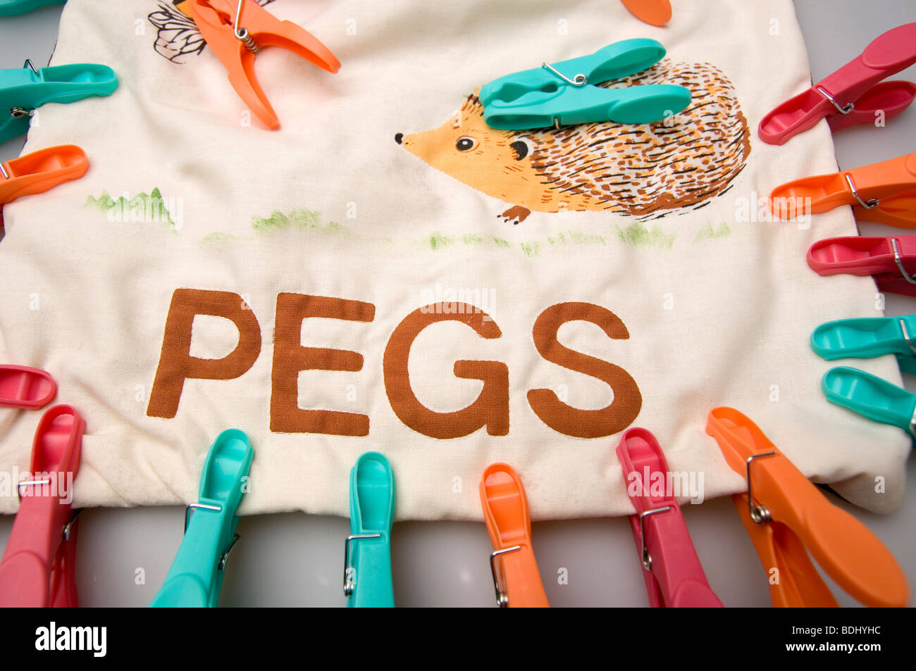 coloured plastic pegs on a hedgehog print peg bag Stock Photo