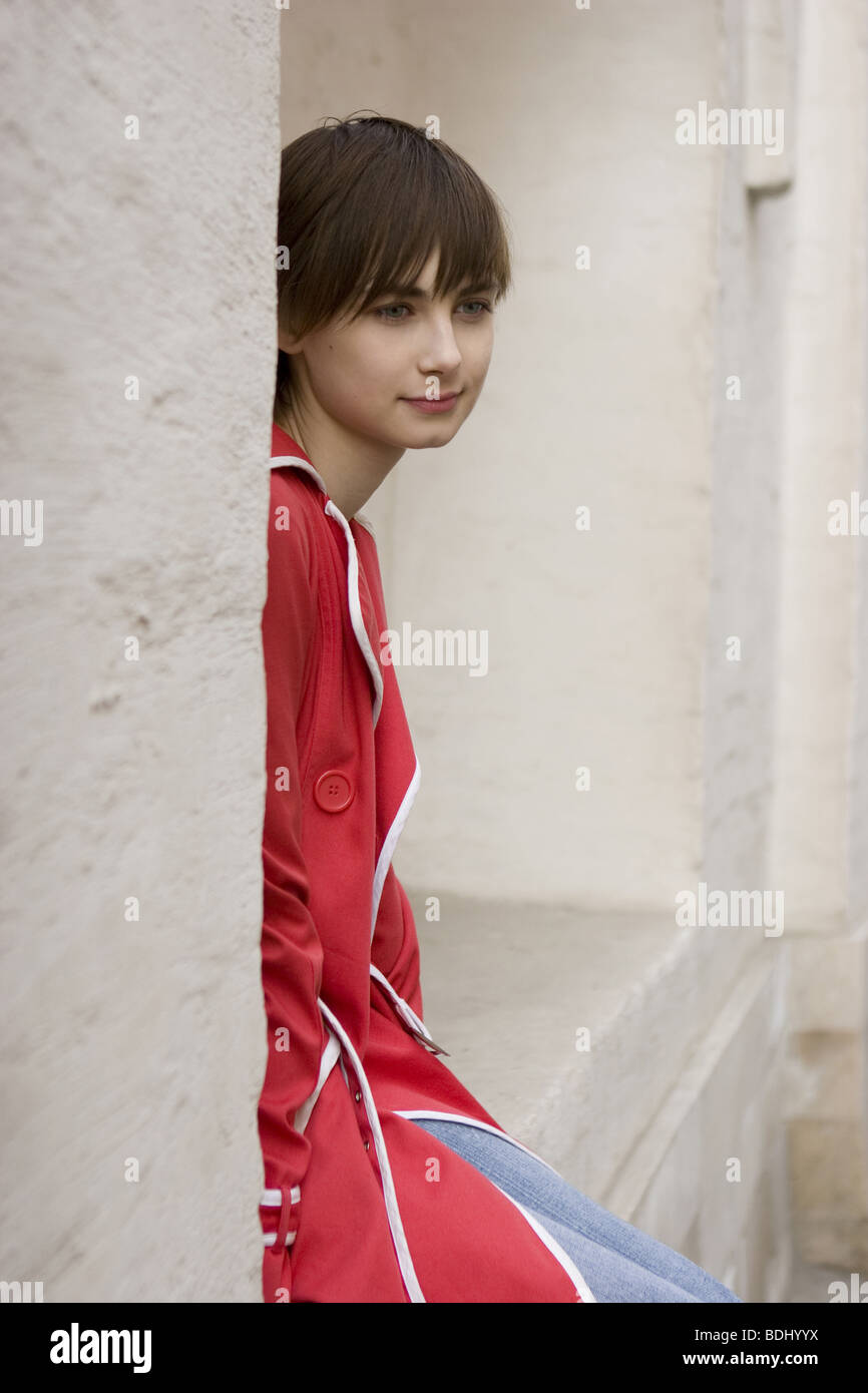 young woman is sitting at the wall Stock Photo