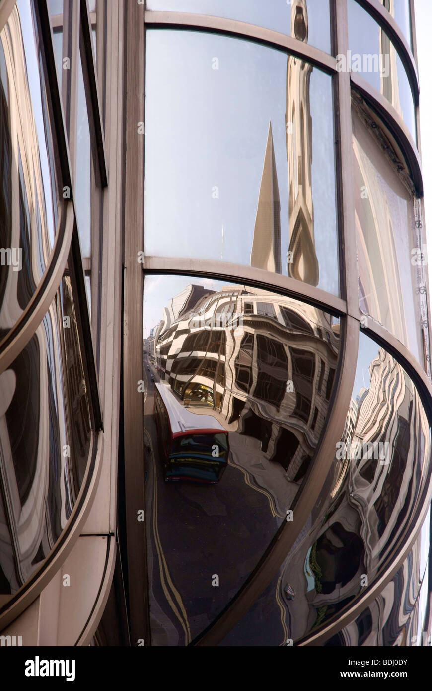 Distorted reflections of a red London doubledeck bus in a city office ...