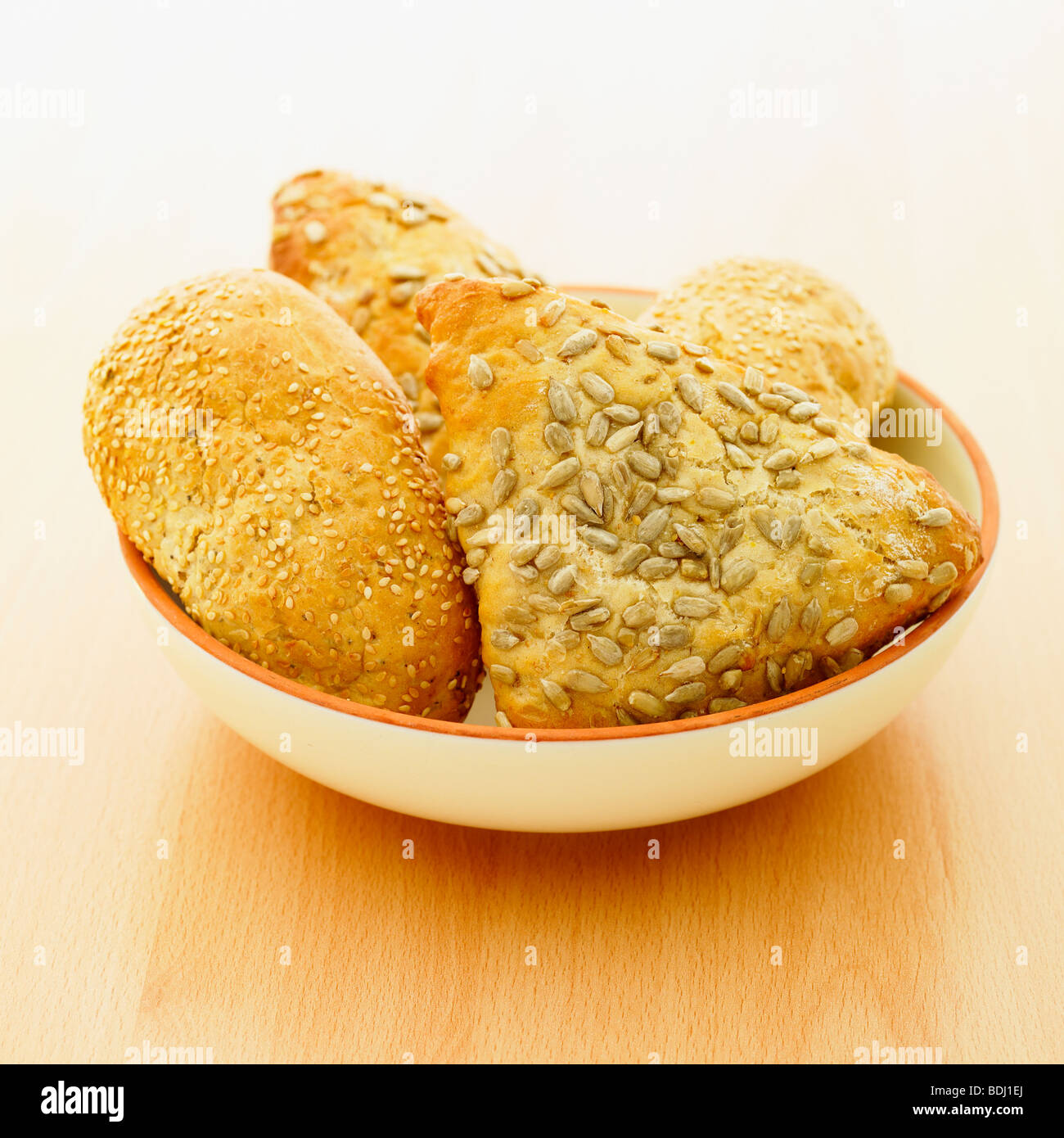 A selection of fresh rustic wholemeal bread rolls in a bowl. Stock Photo
