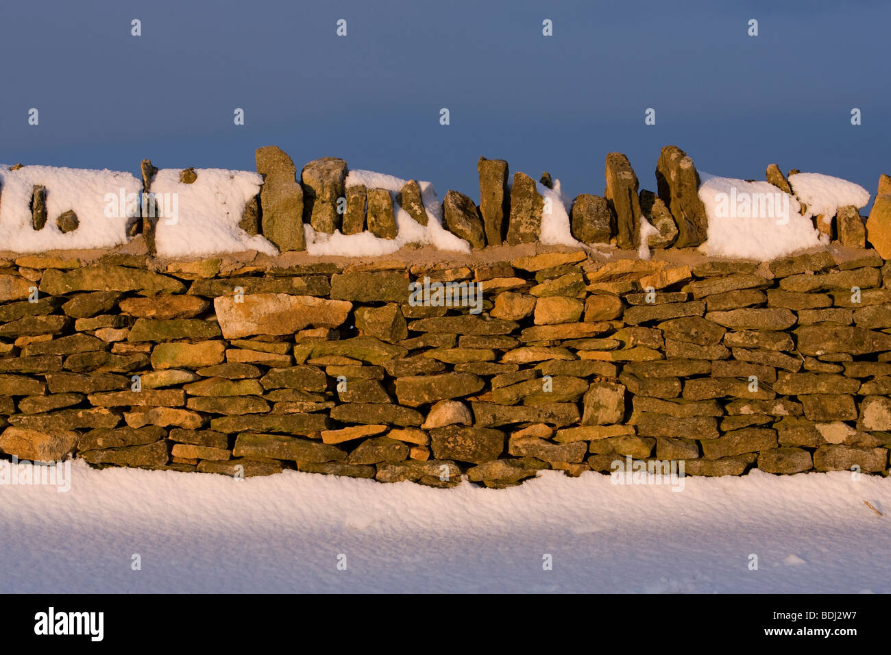 Dry stone wall under a blanket of snow in the Cotswolds, England. Photo taken at sunrise in February 2009 Stock Photo