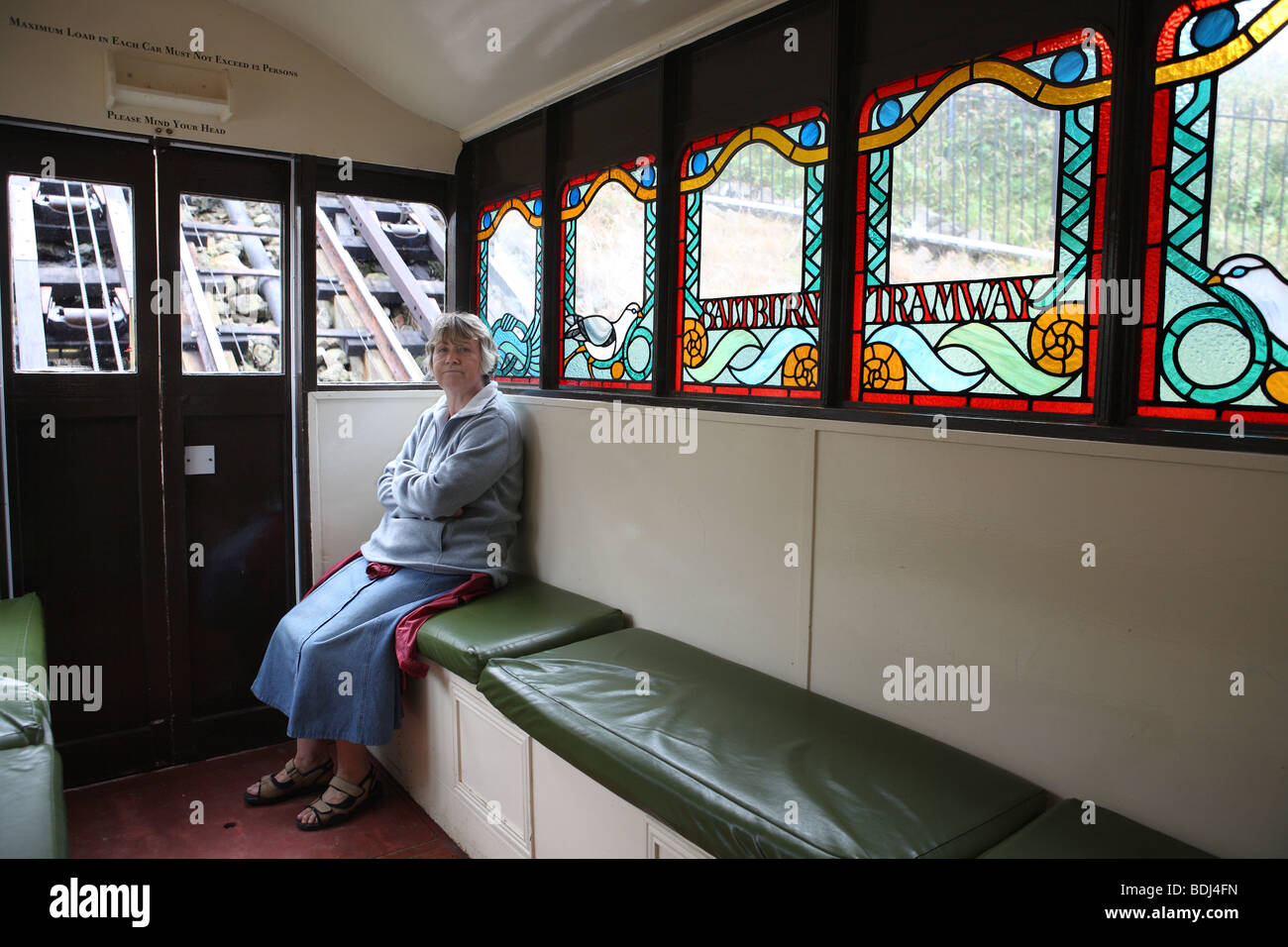 A middle aged woman sits within a carriage of the Saltburn Tramway, North Yorkshire, England, UK Stock Photo