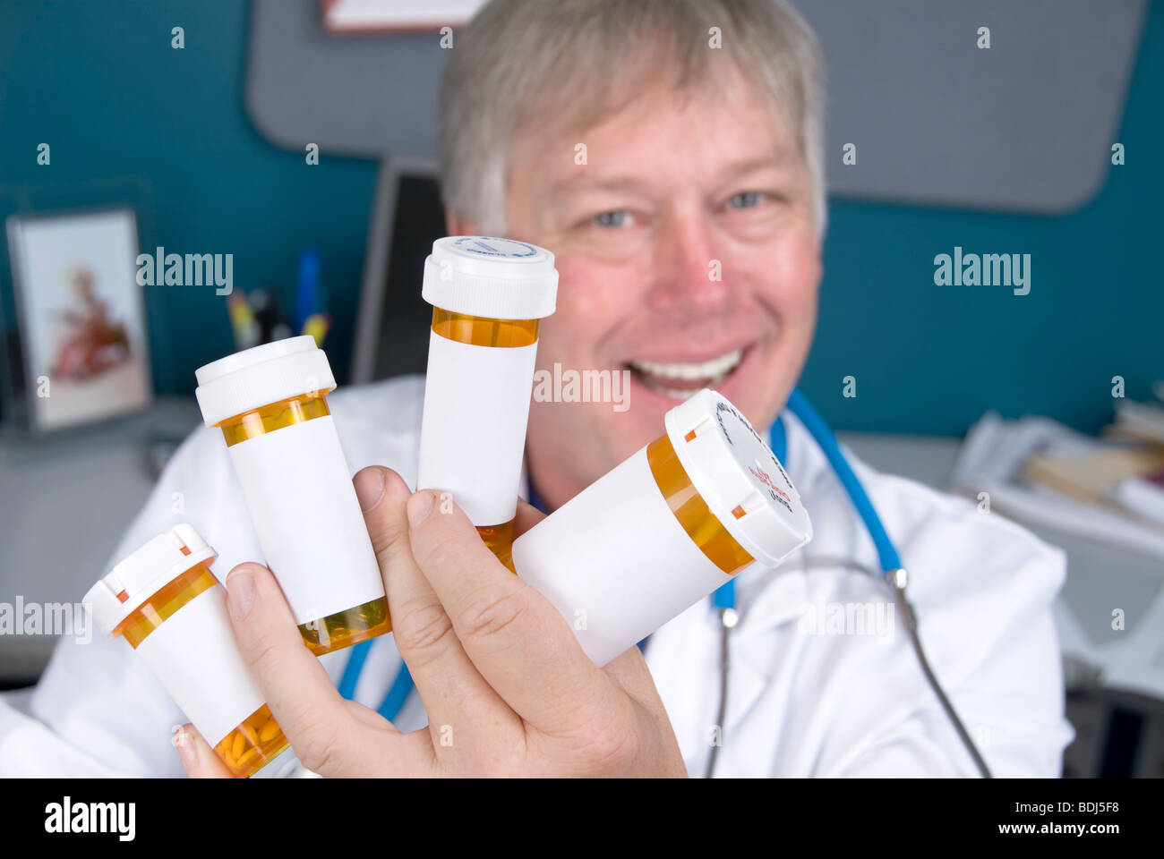 A pharmacist displays pill bottles of medication. Labels are left blank