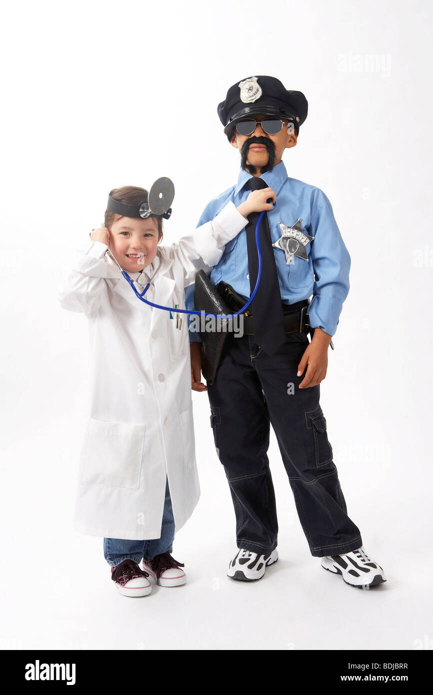 Girl Dressed as Doctor Checking Boy Dressed as Police Officer Stock Photo