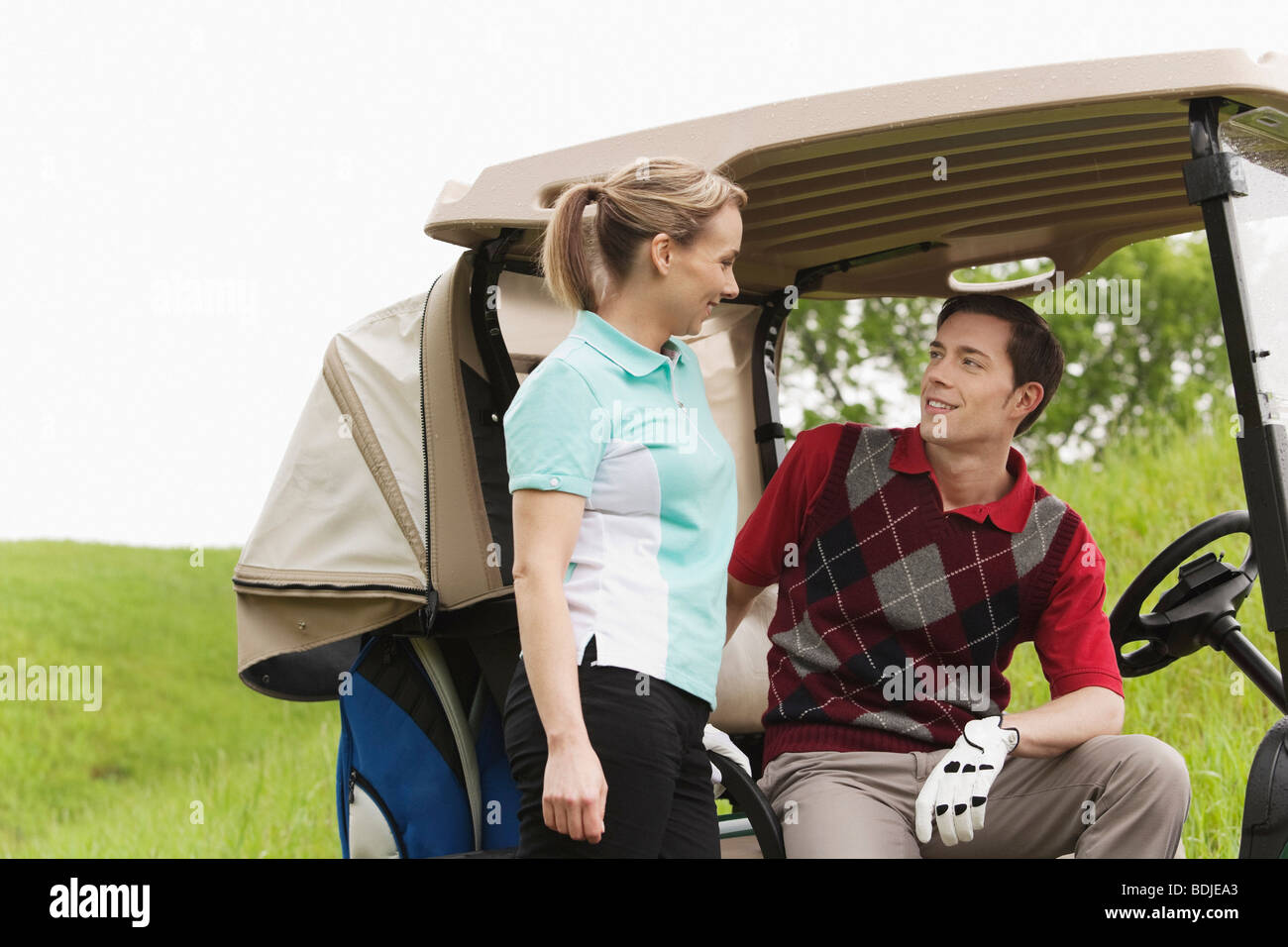 Couple with Golf Cart on Golf Course Stock Photo