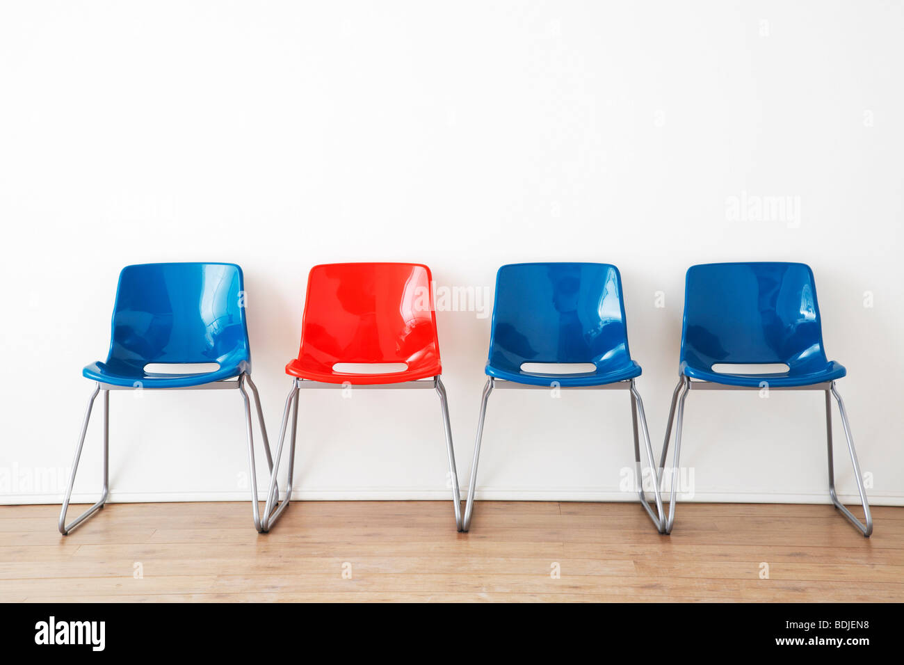 Row of Red and Blue Chairs in Waiting Room Stock Photo