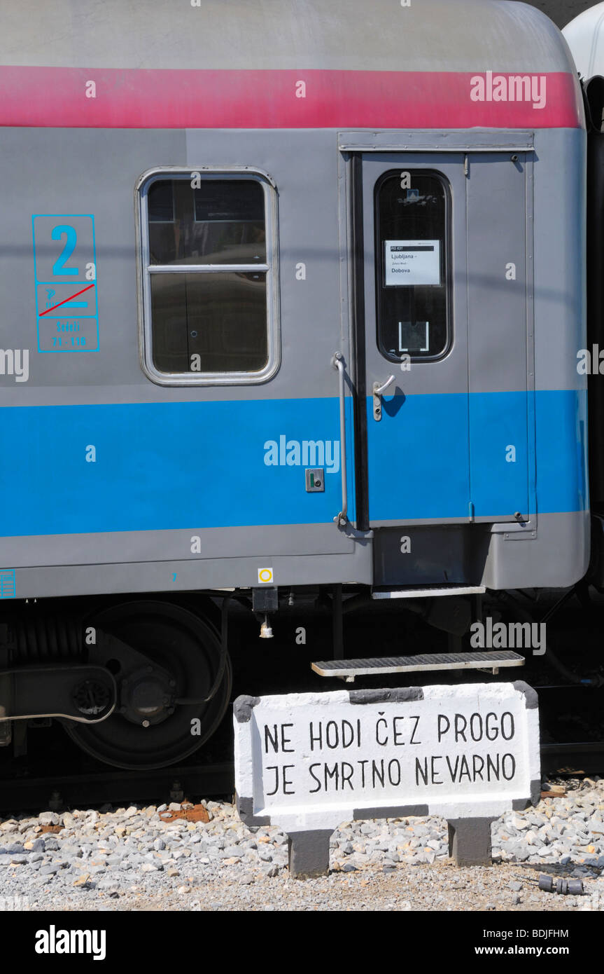 Ljubljana, Slovenia. Train carriage in main railway station. Warning sign 'Do Not Cross the Tracks - Mortal Danger' Stock Photo
