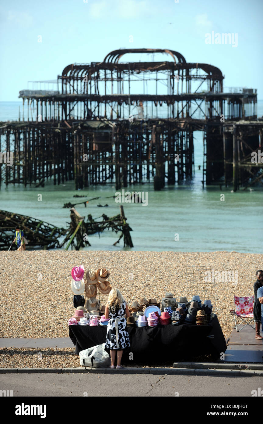 Woman selling sun hats at a stall in front of the West Pier in Brighton UK Stock Photo