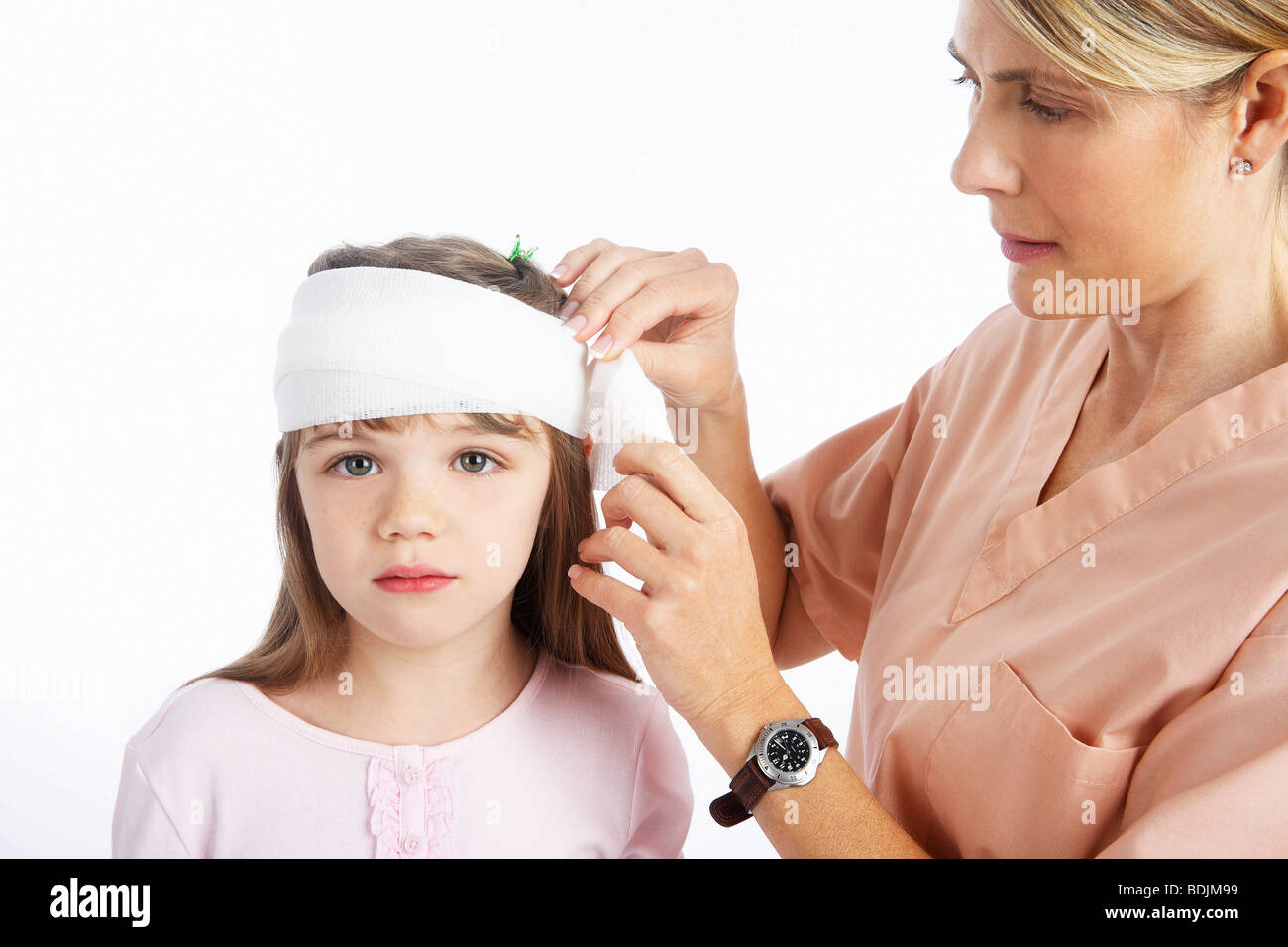 Nurse Wrapping Bandage Around Girl's Head Stock Photo