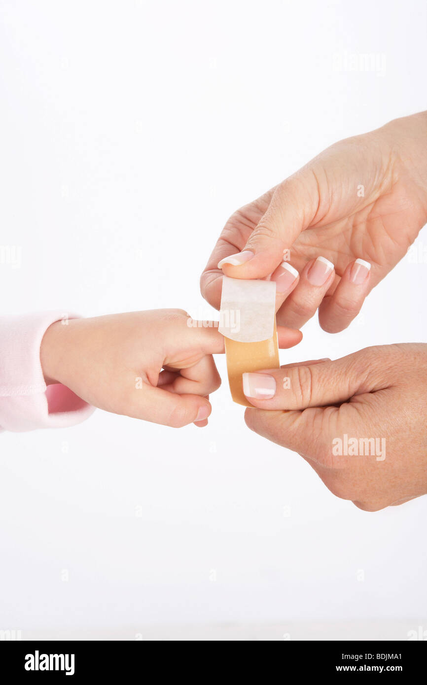 Mom Putting Bandaid on Daughter's Finger Stock Photo Alamy