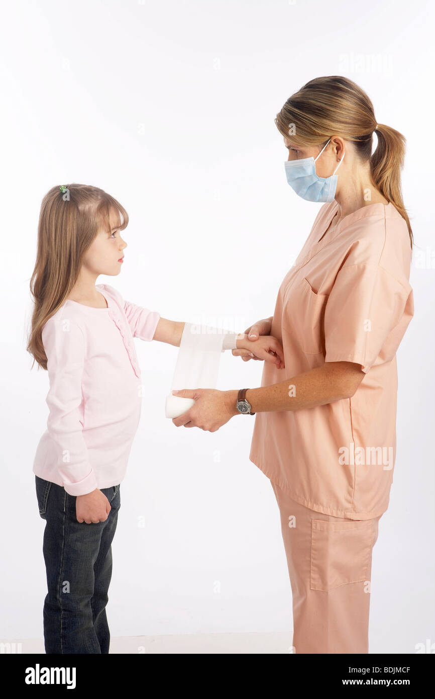 Nurse Wrapping Bandage Around Girl's Arm Stock Photo
