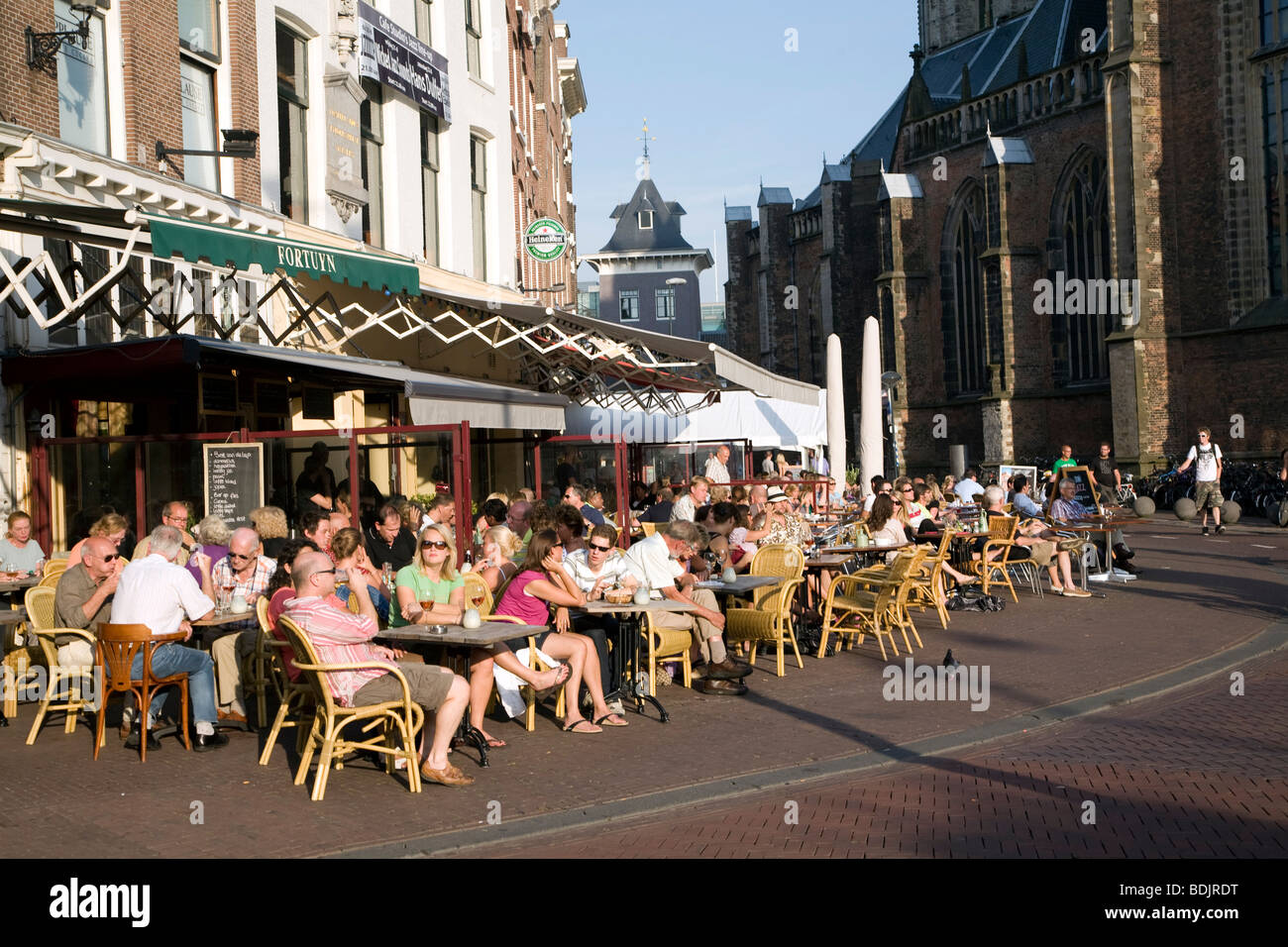 People outside at cafe tables and chairs, Grote Mart, Haarlem, Holland Stock Photo
