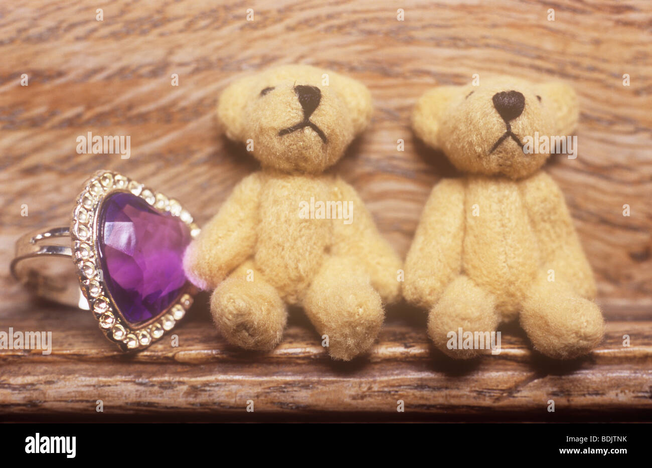 Young girl or teenager collection of purple heart ring and two small teddy bears on wooden ledge Stock Photo