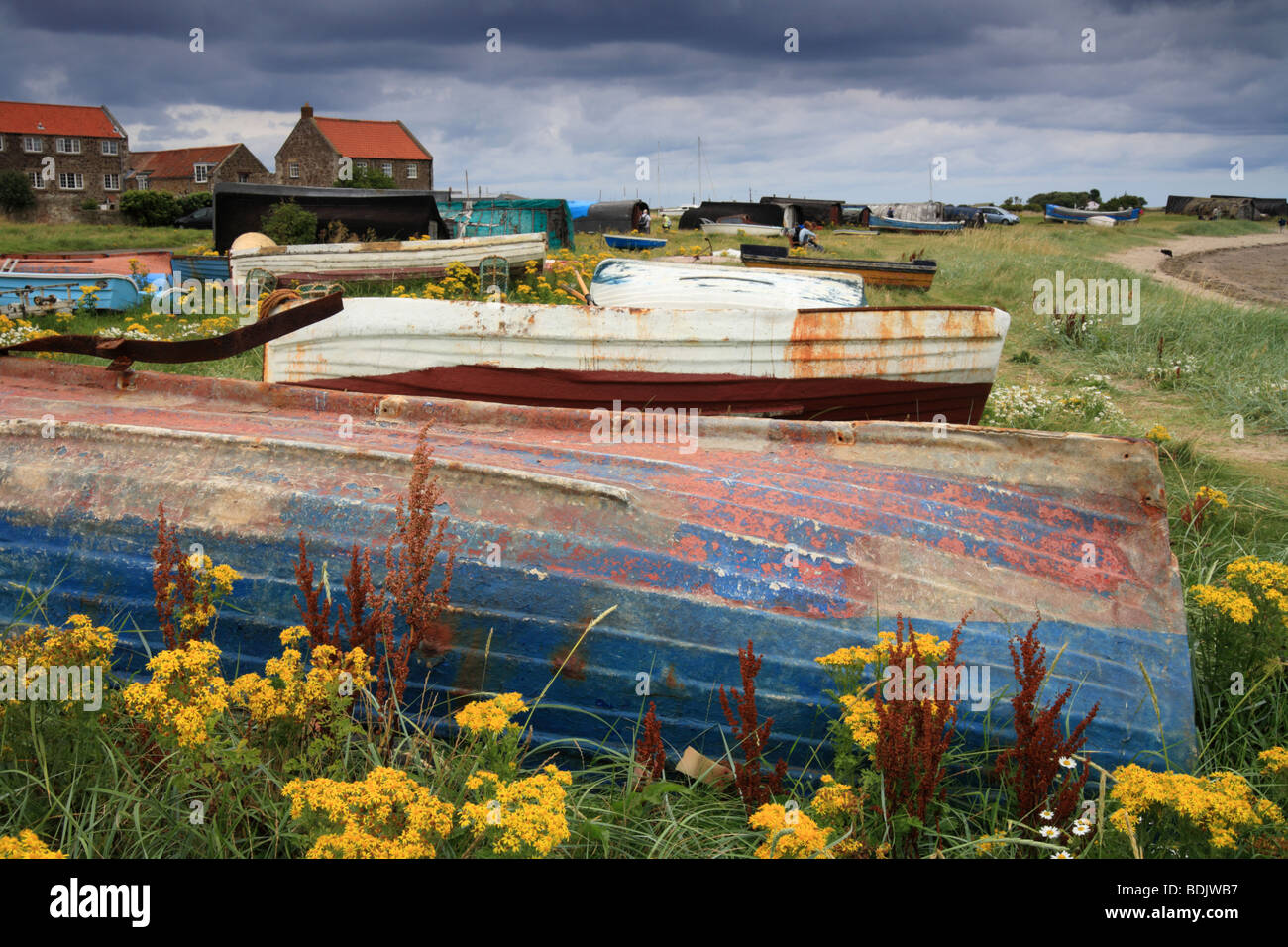 Fishing Boats upturned on the shore, Holy Island Harbour, Lindisfarne, Northumberland, England, UK Stock Photo