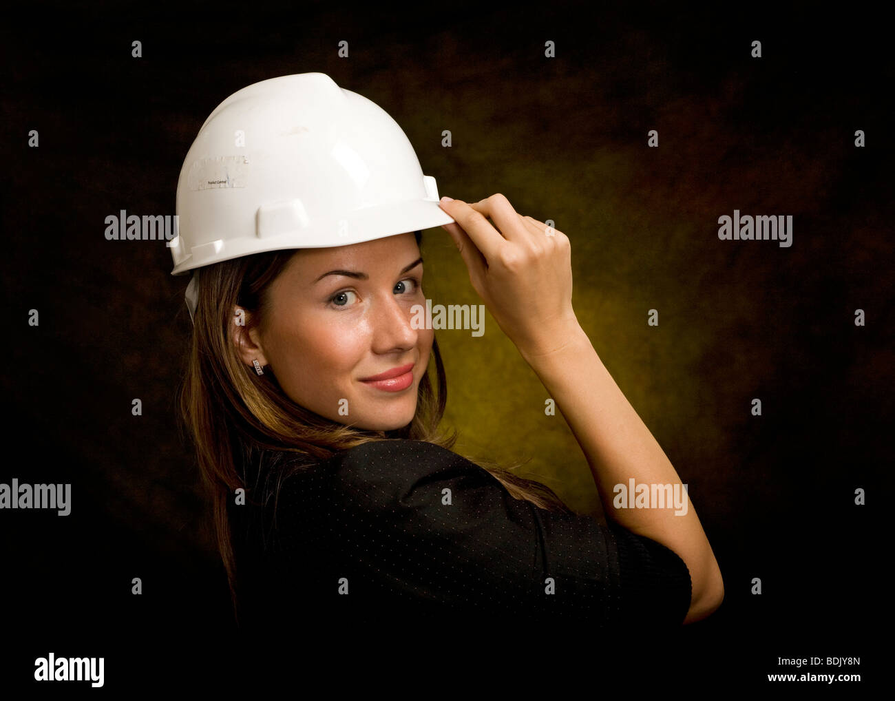 Young Caucasian female wearing a hardhat in studio Stock Photo