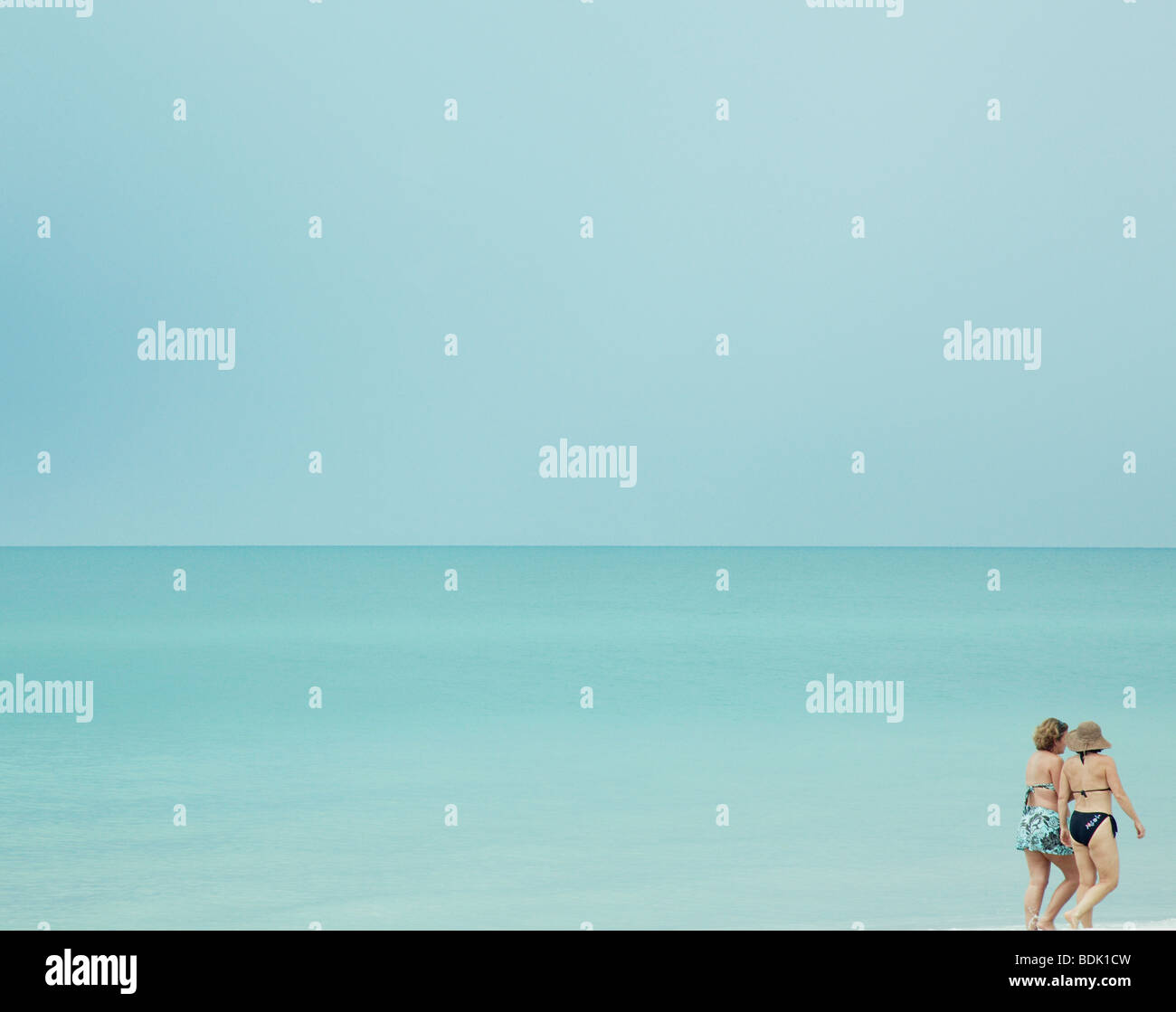 couple of woman enjoy a stroll along a beach in Florida Stock Photo