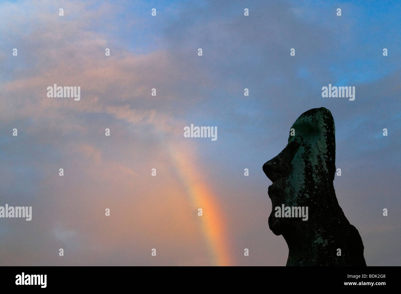 A lone Moai (volcanic stone sculptures) with rainbow at Ahu Tongariki, Easter Island, Chile Stock Photo