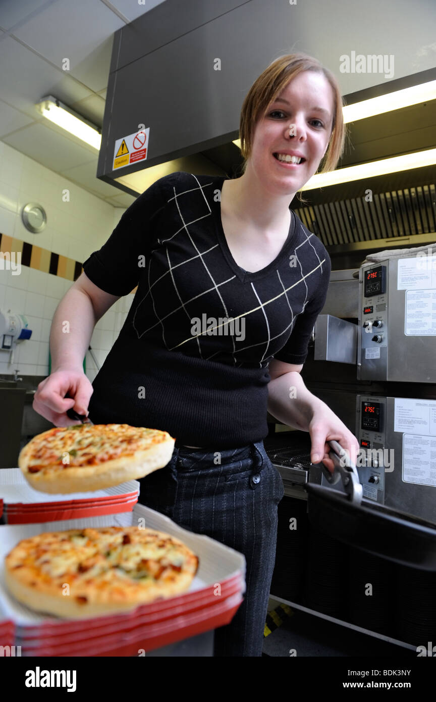 GIRL SERVING PIZZA IN A FAST FOOD RESTAURANT UK Stock Photo