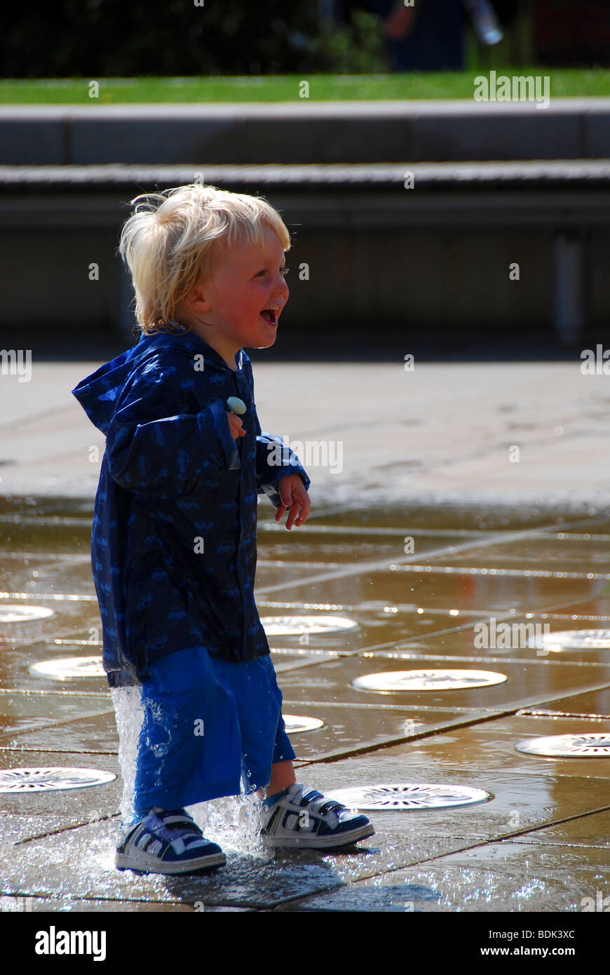 Small boy playing in the water fountain Stock Photo