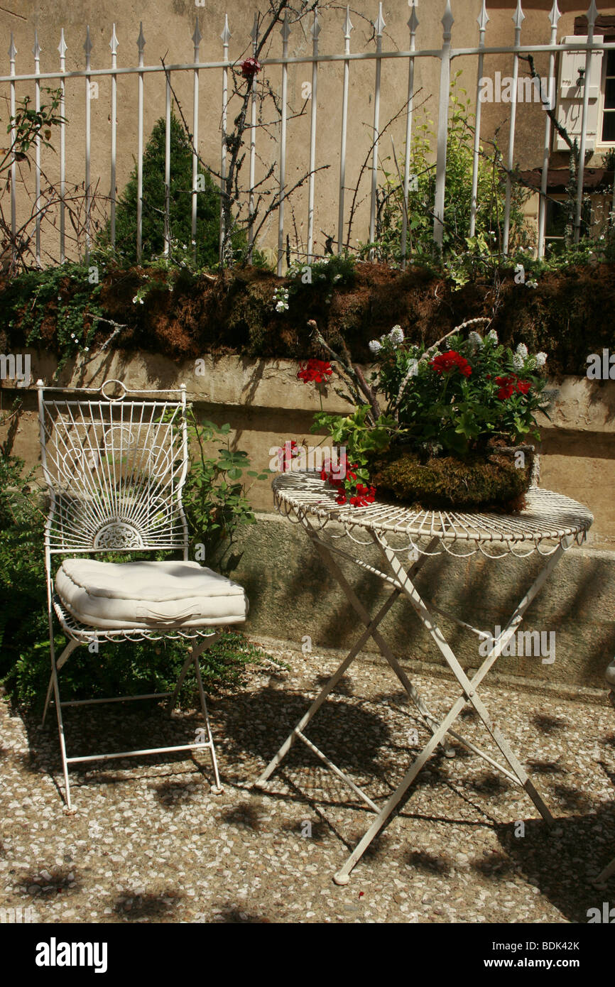Pretty garden chair and table on the pavement of the little town of Beaumont du Perigord, France Stock Photo