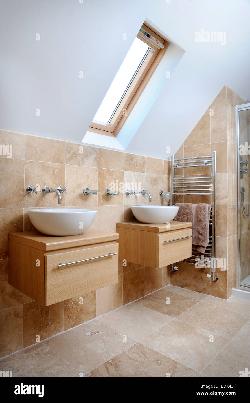 A MODERN BATHROOM WITH TWIN SINKS AND VELUX ROOF WINDOW Stock Photo