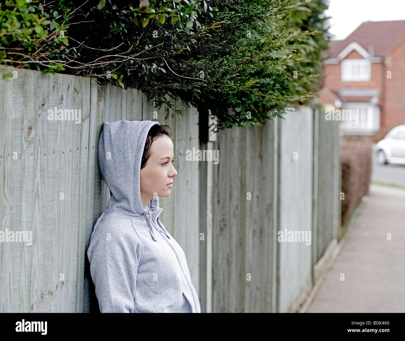 jogger resting against wooden fence Stock Photo