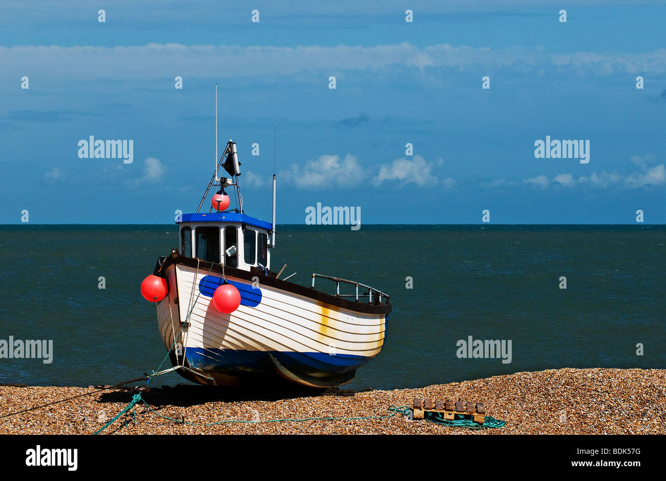 A fishing boat beached on the shingle at Dungeness in Kent. Stock Photo
