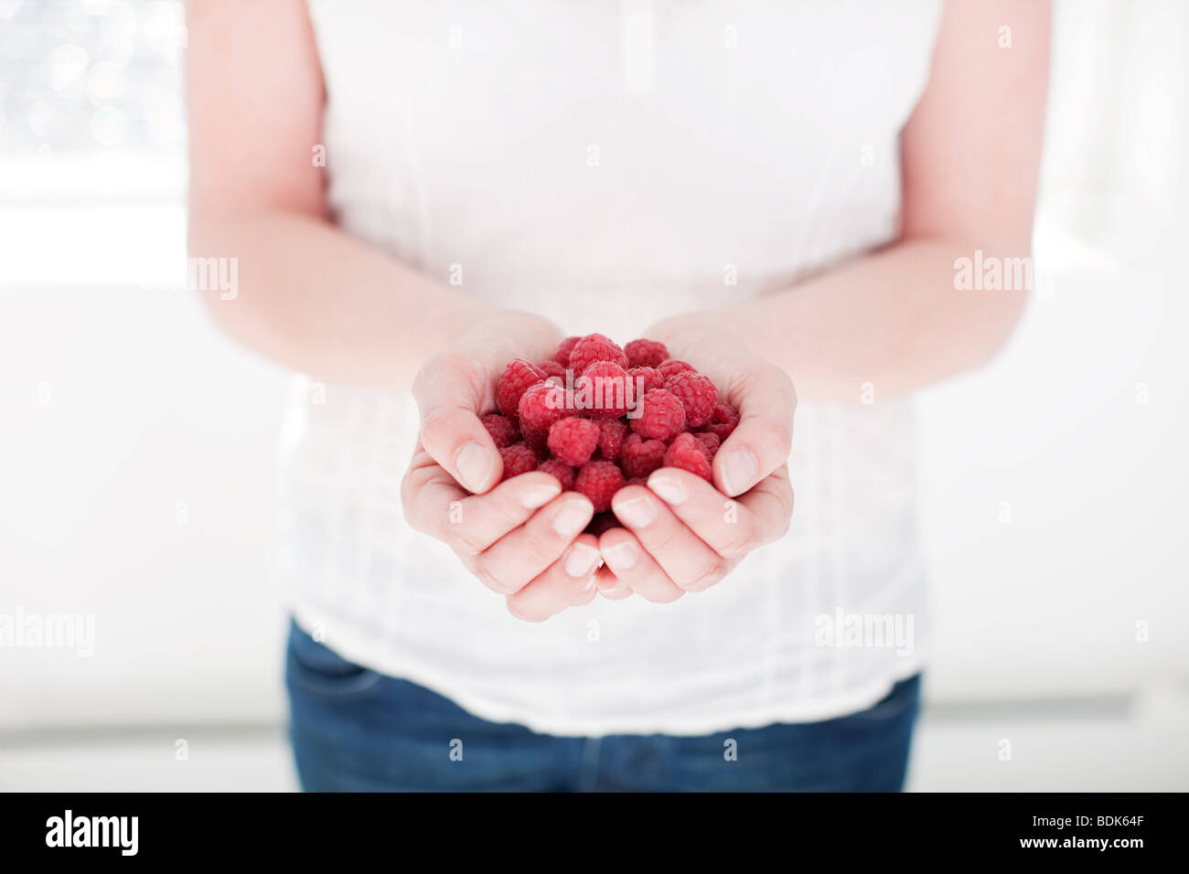 Woman holding raspberryies Stock Photo - Alamy