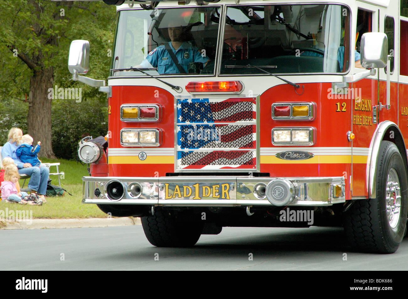 Fire department vehicles being driven in a fire muster parade. Stock Photo