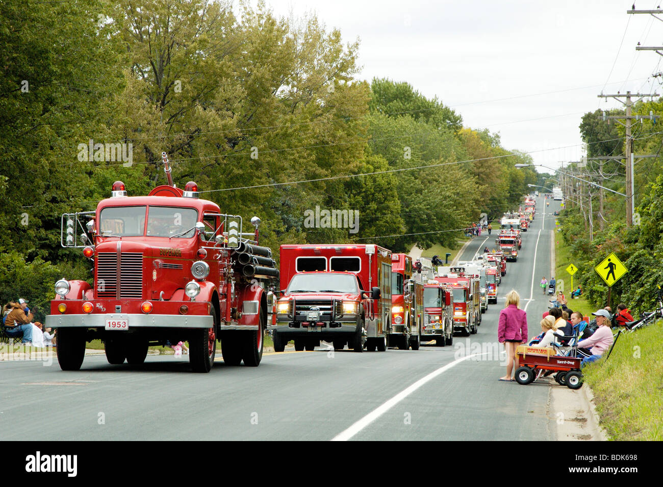 Fire department vehicles being driven in a fire muster parade. Stock Photo