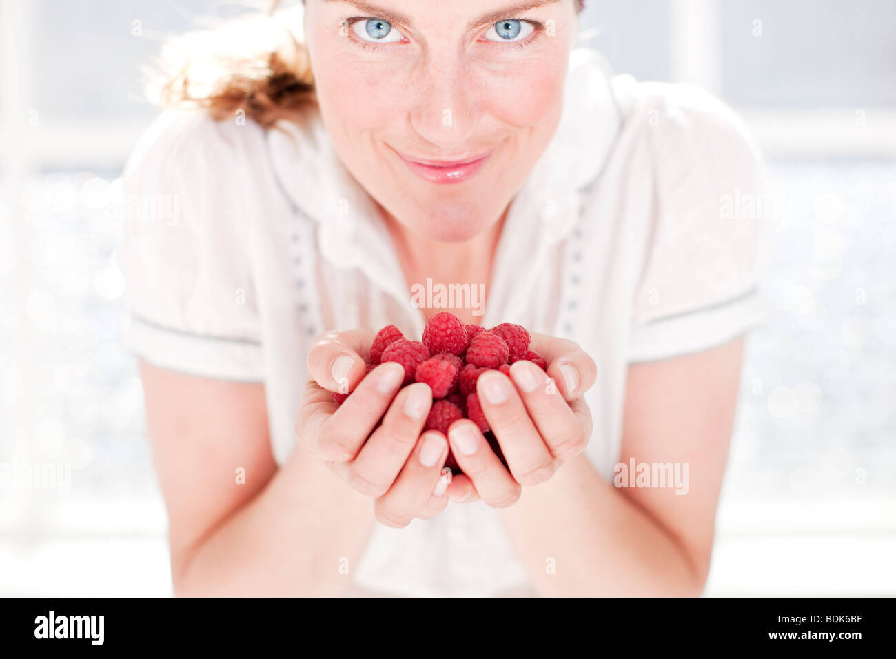 Woman holding raspberryies Stock Photo - Alamy