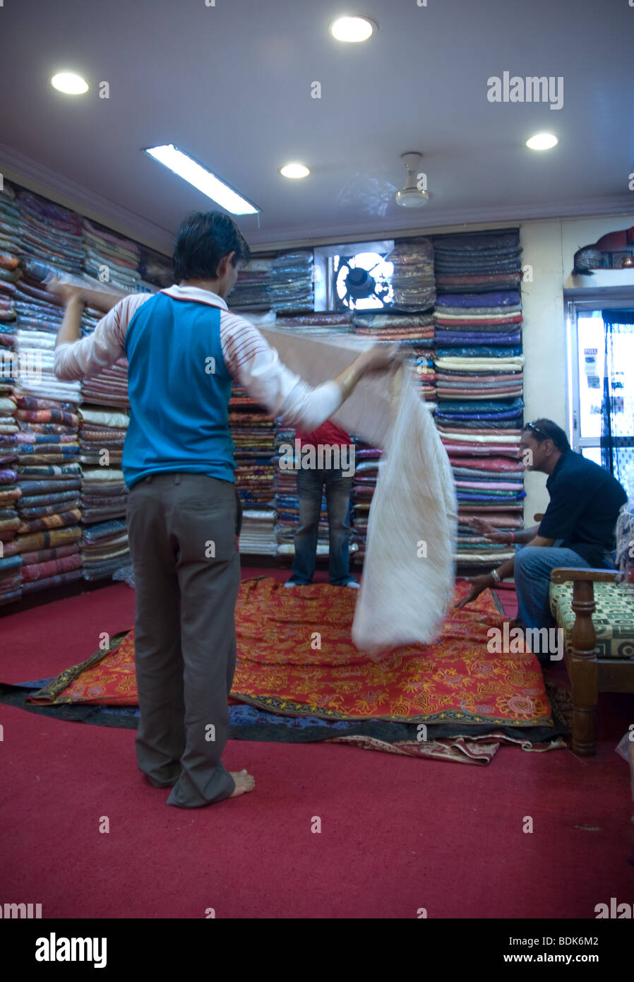shopkeeper's show off fabrics to a customer Stock Photo