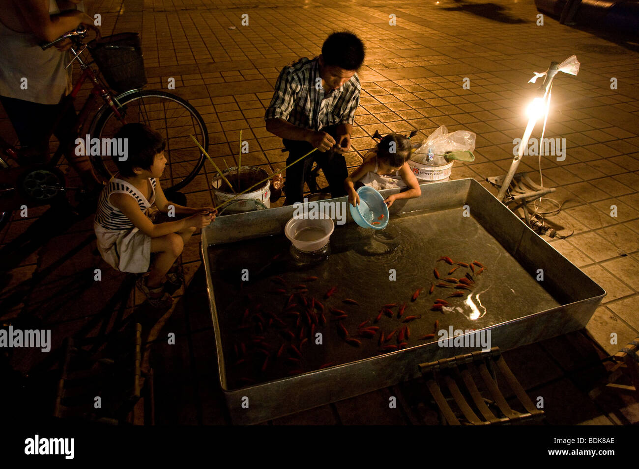Children playing at night at a fishing game in the main square, Wu Hai, Inner Mongolia, China Stock Photo