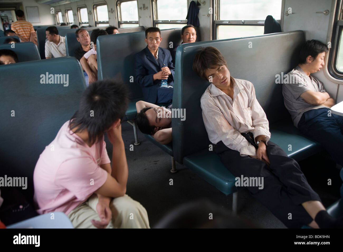 JIEXIU, SHANXI PROVINCE, CHINA - AUGUST 2007: Passengers on an inter-city train sleep in the early morning. Stock Photo