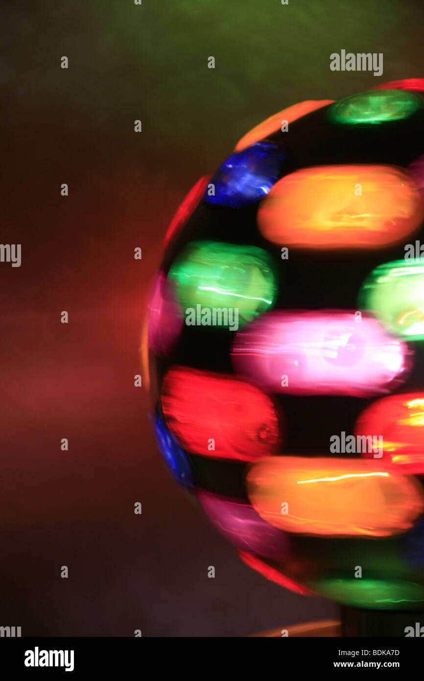 rotating toy ball with colourful lights on table in dark room Stock Photo