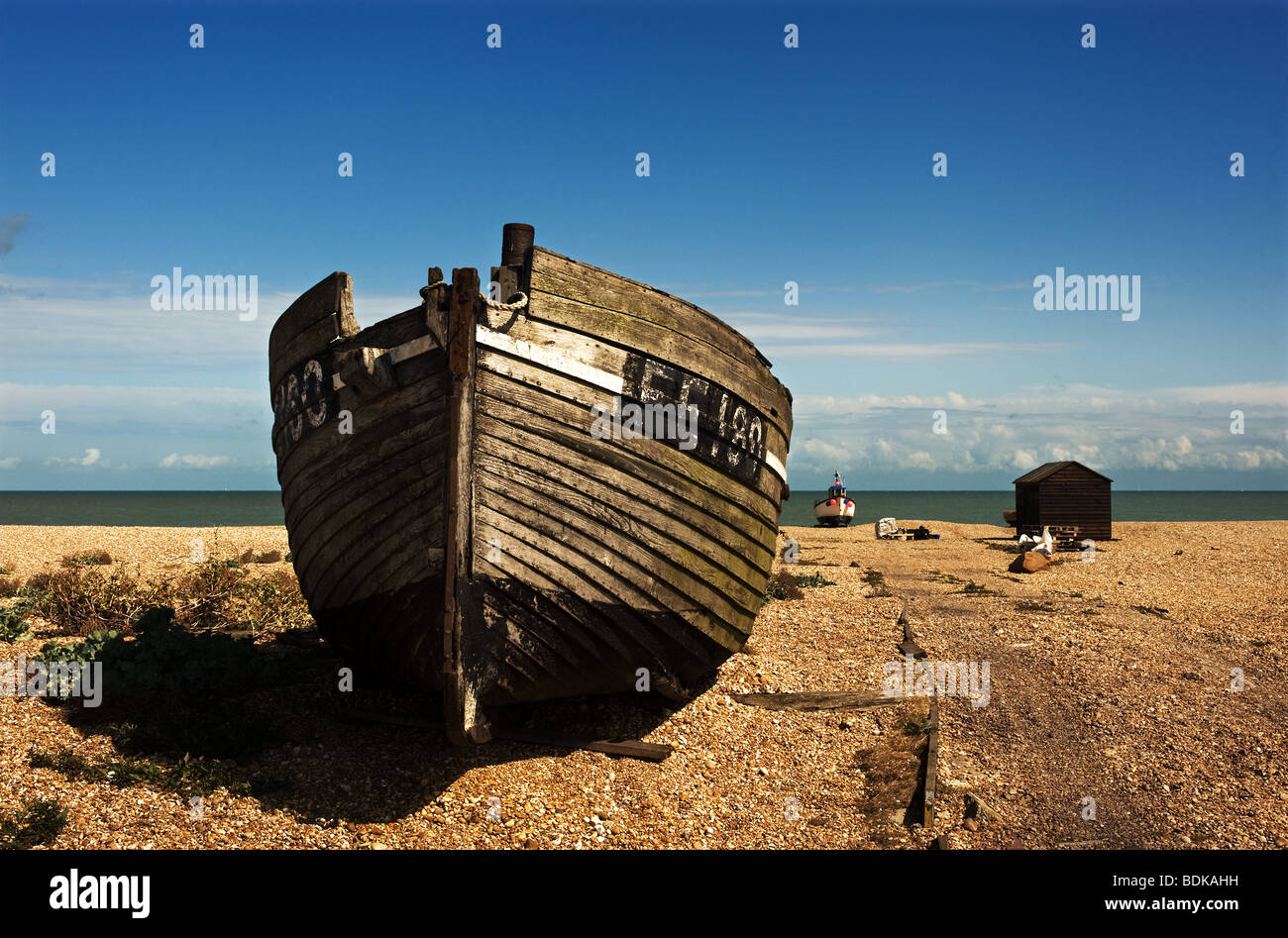 An abandoned wooden fishing boat on the shingle at Dungeness in Kent ...