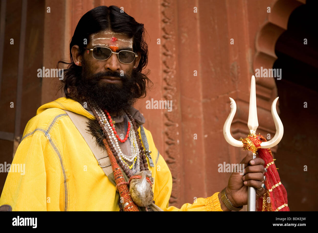 A Sadhu holds a trident in the Indian city of Varanasi (Benares). He is a Shiva devotee and a pujari (Hindu priest). Stock Photo