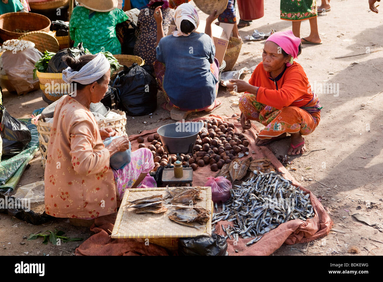 Indonesia, Lombok, Kuta, weekly market woman selling ikan bilis dried fish and salat snake fruit Stock Photo