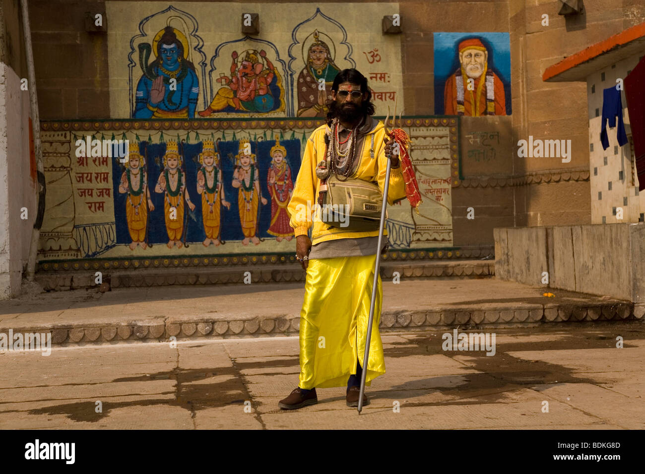 A Sadhu in the Indian city of Varanasi (Benares). He stands in front of a painted temple. Stock Photo