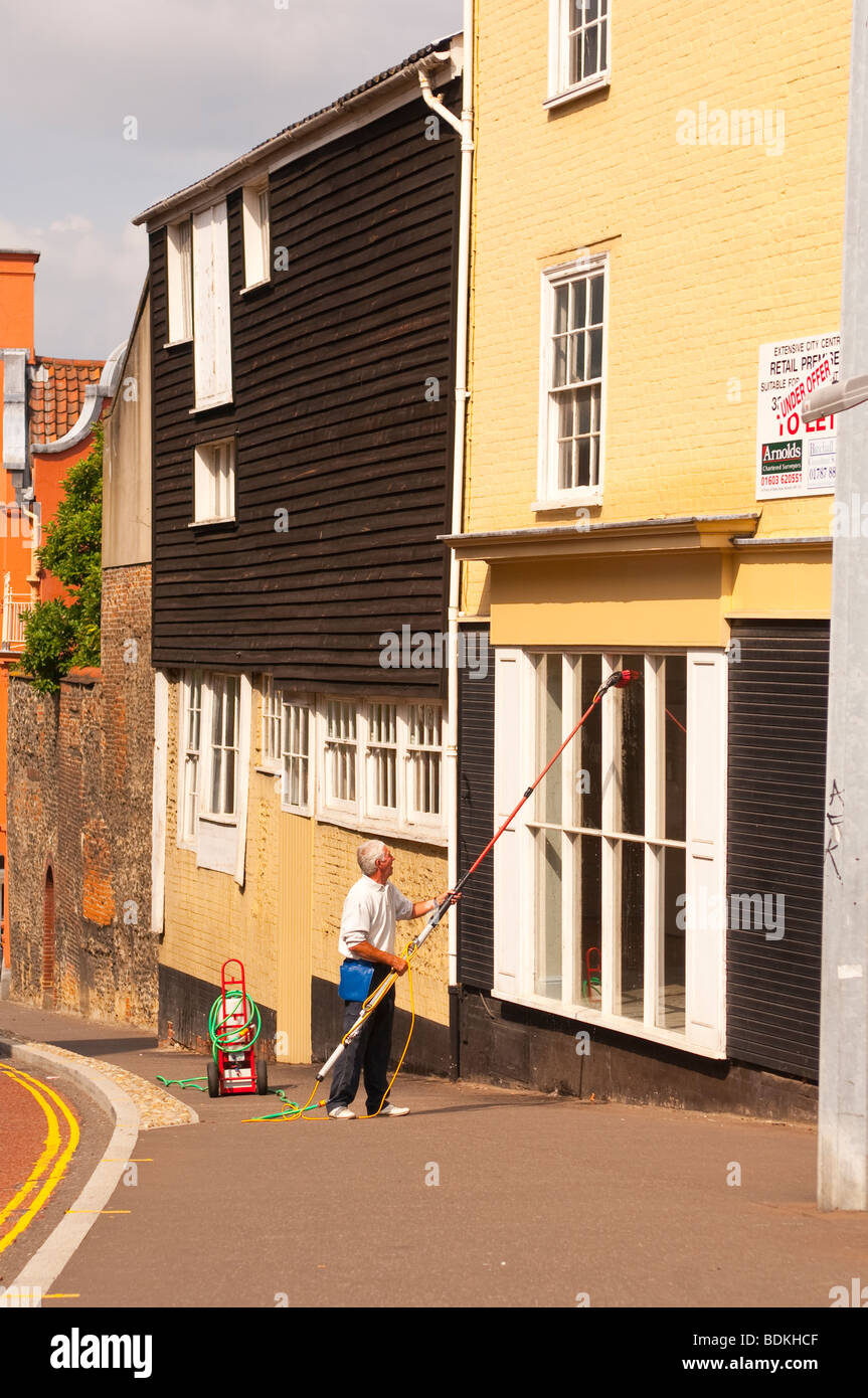 A window cleaner cleaning windows using a pole water system in Norwich