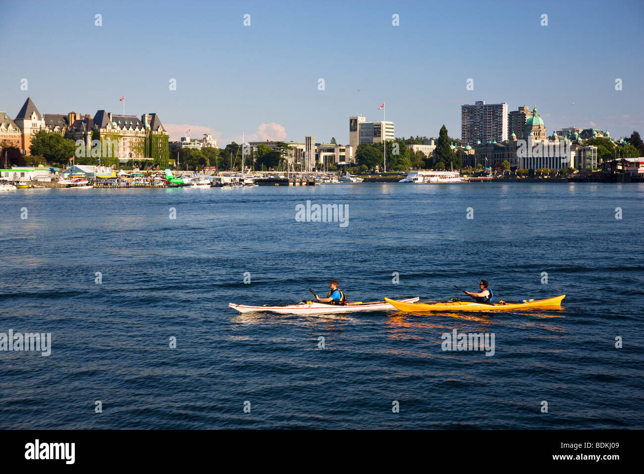 Kayakers pass Songhees Viewpoint in the Inner Harbour, Victoria, Vancouver Island, British Columbia, Canada. Stock Photo