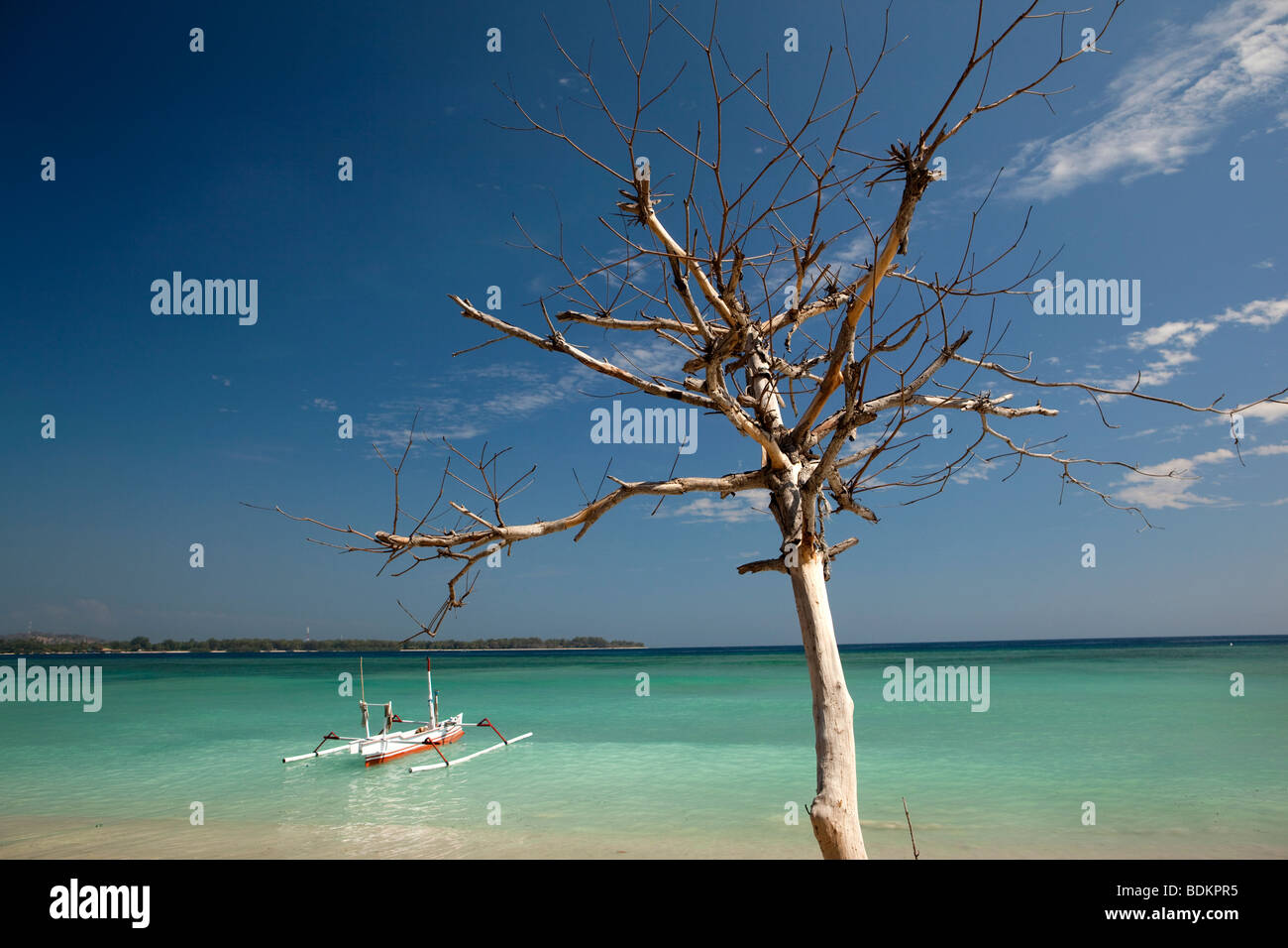 Indonesia, Lombok, Gili Air, white and blue painted outrigger boat moored in idyllic aquamarine sea Stock Photo