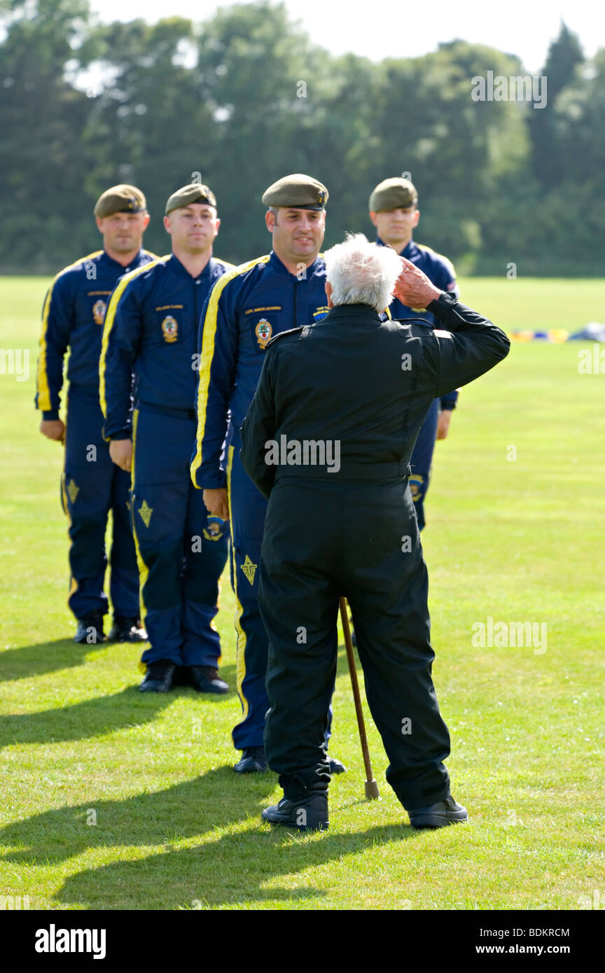 Former RAF serviceman, eighty-eight-year-old Tom Lackey takes the salute from members of the Red Devils parachute team. Stock Photo