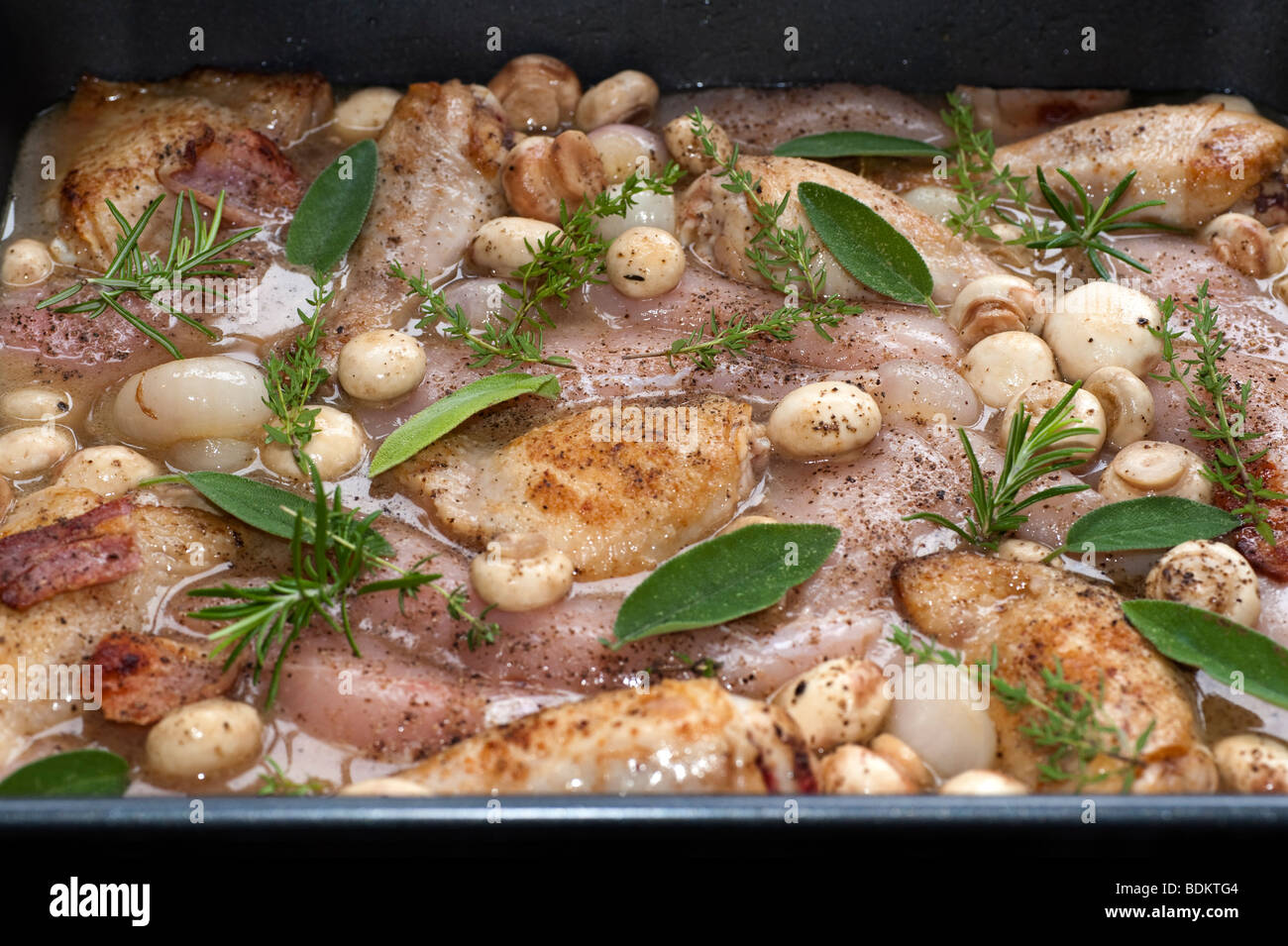 Chicken Casserole dish with herbs and mushrooms ready to be cooked in an oven Stock Photo